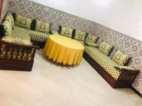 un soggiorno con divano e tavolo giallo di Charmant appartement ad Al-Ḥoseyma