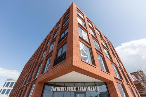 un edificio de ladrillo rojo con un cartel. en Aparthotel Timmerfabriek Apartments I Kloeg Collection, en Vlissingen
