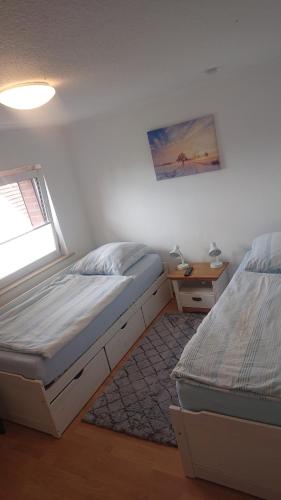 a bedroom with two twin beds and a window at Ferienwohnung Ehmen in Wolfsburg