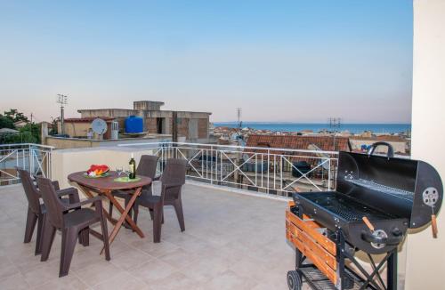 balcón con mesa, sillas y parrilla en Coconut Tree House with port view en Zakynthos