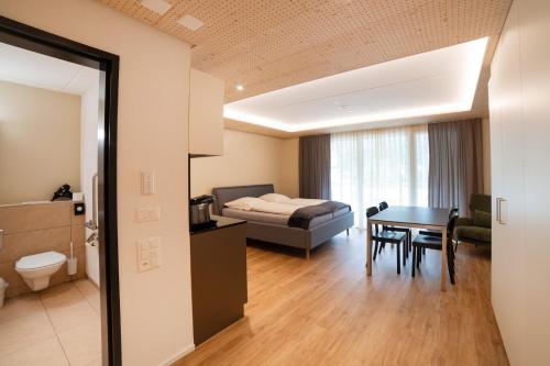 a room with a bed and a table and a bedroom at WAZ Wohnen auf Zeit - Flums in Flums