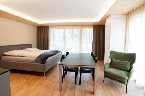 a bedroom with a bed and a table and a chair at WAZ Wohnen auf Zeit - Flums in Flums