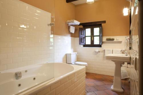 a bathroom with a tub and a toilet and a sink at HOTEL RURAL ARREDONDO in Celorio