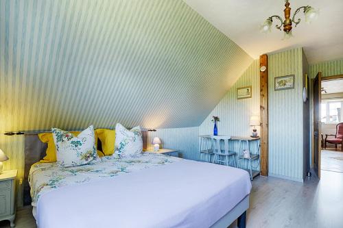 a bedroom with a white bed with blue and white pillows at aux pieds des vignes in Ingersheim