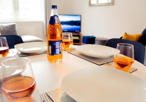 a bottle of beer sitting on a table with glasses at 10 Bynack House in Aviemore