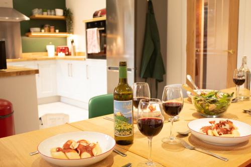 a table with a bottle of wine and two glasses at Burnside Pines in Aviemore