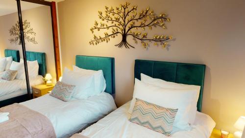 a bedroom with two beds and a mirror at Burnside Pines in Aviemore