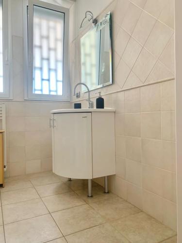a white bathroom with a sink and a mirror at Le dimore di Fedra in Bari