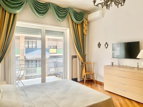 a bedroom with a bed and a tv and a window at Le dimore di Fedra in Bari
