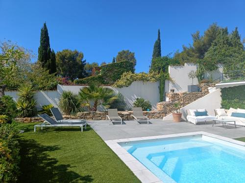 une cour avec une piscine, des chaises et une cour dans l'établissement Villa contemporaine Piscine chauffée,pétanque, Clim, à Ceyreste