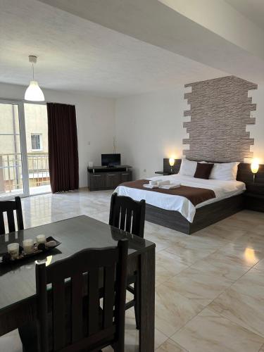 a bedroom with a large bed and a dining table at Къща за гости Golden Reef in Tsarevo