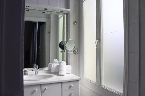 a bathroom with a sink and a mirror at La Souveraine in Contrexéville