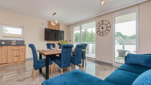 una cucina e una sala da pranzo con tavolo e sedie blu di Baltic Garden, Sun & Snow a Sztutowo