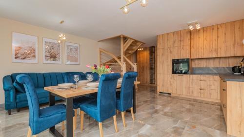 una cucina e una sala da pranzo con tavolo e sedie blu di Baltic Garden, Sun & Snow a Sztutowo