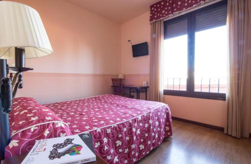 um quarto de hotel com uma cama e uma janela em Prado de las merinas em Caleruega