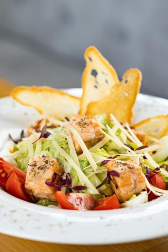 a bowl of salad with meat and vegetables on a table at SVOI Hotel in Palyanytsya