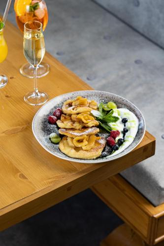 a plate of pancakes and berries on a wooden table at SVOI Hotel in Palyanytsya