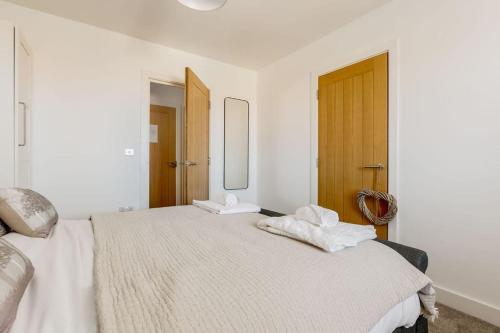 Dormitorio blanco con cama grande y espejo en Modern 1 Bed, close to beach and highstreet, en Southbourne