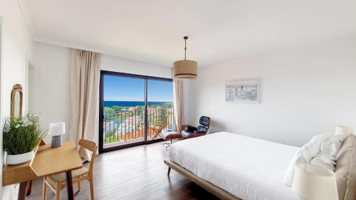 ein Schlafzimmer mit einem Bett, einem Schreibtisch und einem Fenster in der Unterkunft Costa Vista by LovelyStay in Funchal