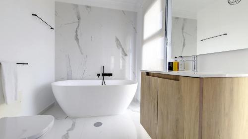 ein weißes Badezimmer mit Badewanne und Waschbecken in der Unterkunft Costa Vista by LovelyStay in Funchal