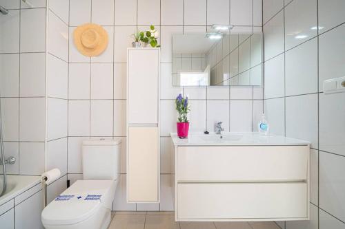 ein Badezimmer mit einem WC, einem Waschbecken und einem Spiegel in der Unterkunft Bungalow limoneros Spaniahome in Foyes Blanques