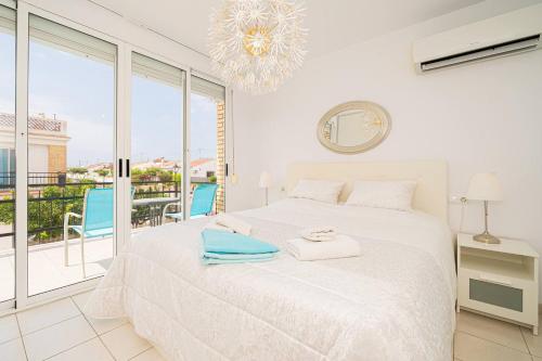 ein weißes Schlafzimmer mit einem Bett und einem Balkon in der Unterkunft Bungalow limoneros Spaniahome in Foyes Blanques