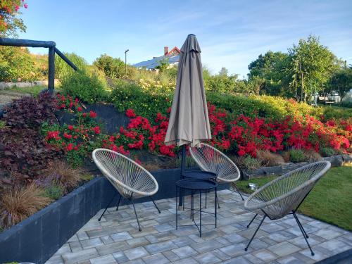 two chairs and an umbrella on a patio at Dom gościnny u Krupów in Polańczyk
