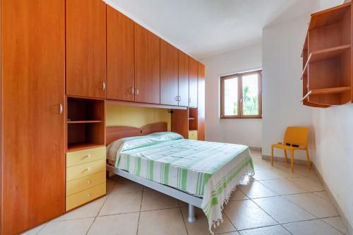 a bedroom with a bed and wooden cabinets at Villa Alba fronte mare in Carovigno