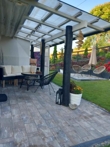 a patio with a pergola and a table and chairs at Dom gościnny u Krupów in Polańczyk
