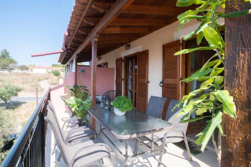 a table and chairs on the balcony of a house at Studio Dionphaie - Διόνφαιη in Pylos