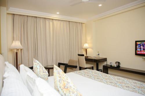 a hotel room with two beds and a desk at Citrus Prime Raipur in Raipur