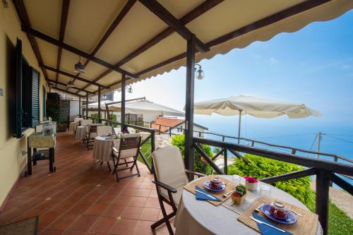 a patio with tables and chairs and a view of the ocean at Solaria in Amalfi