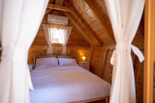ein Schlafzimmer mit einem Bett in einer Holzhütte in der Unterkunft Dionis Zaton - Camping, Glamping, Holiday Houses & Rooms in Zaton