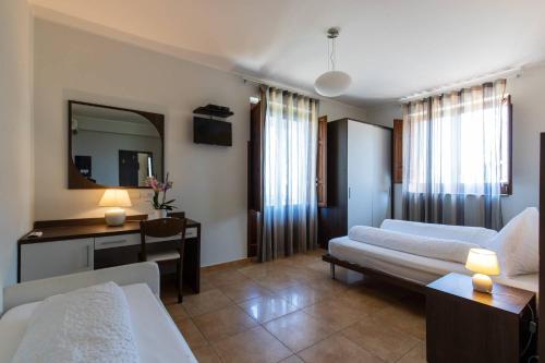 a hotel room with two beds and a desk and a mirror at Villa Ginevra Resort Agrituristico in Ficarra