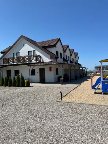 ein Gebäude mit einem Spielplatz davor in der Unterkunft Ośrodek SEVEN in Sarbinowo