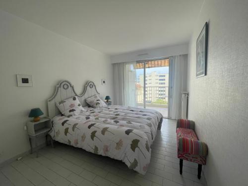 une chambre avec un lit et une grande fenêtre dans l'établissement One Bedroom Apartment Terrasse near the beach, à Cannes