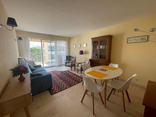 un salon avec une table et un canapé dans l'établissement One Bedroom Apartment Terrasse near the beach, à Cannes