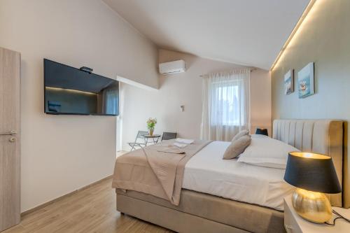 una camera con letto e TV a parete di Beach Residence Parat a Kaštela (Castelli)