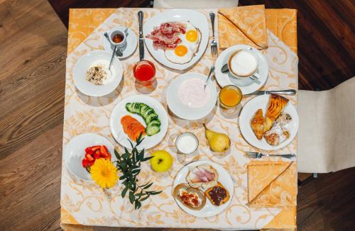 a table with plates of food on a table at Hotel Bel Soggiorno in Malosco