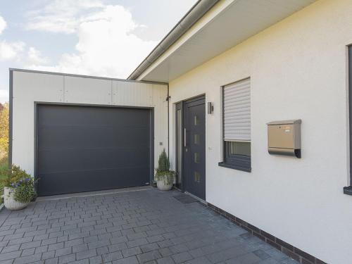 a garage with a black garage door on a house at Ferienhaus Barbara, FeWo Vermittlung Nordsee in Varel