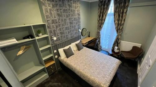 um pequeno quarto com uma cama e uma janela em Charlotte Guest House em Londres