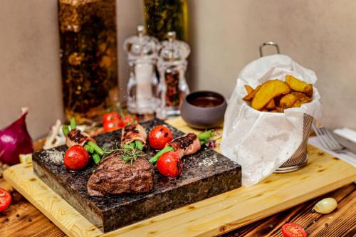 a table with meat and vegetables and a bag of chips at Silvanus Hotel in Visegrád