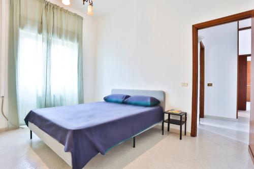 a bedroom with a bed with blue pillows on it at Bright Apartment near the sea with parking in Salerno