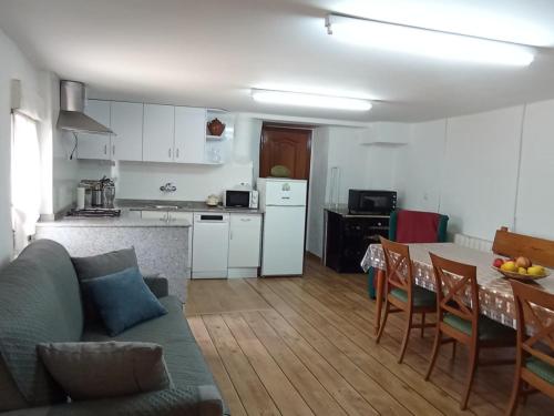 cocina y sala de estar con sofá y mesa en Casa rural La Barriada de Lago de Carucedo, en Lago de Carucedo