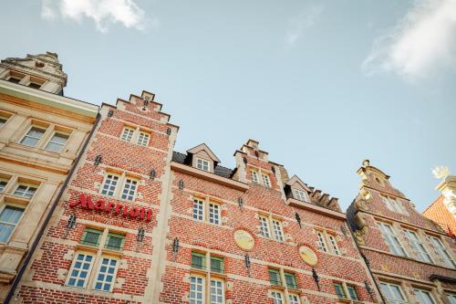 un grand bâtiment en briques avec des fenêtres sur son côté dans l'établissement Ghent Marriott Hotel, à Gand