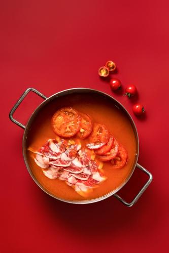 a pan filled with tomato soup on a red background at Le Meridien Xi'an Chanba in Xi'an