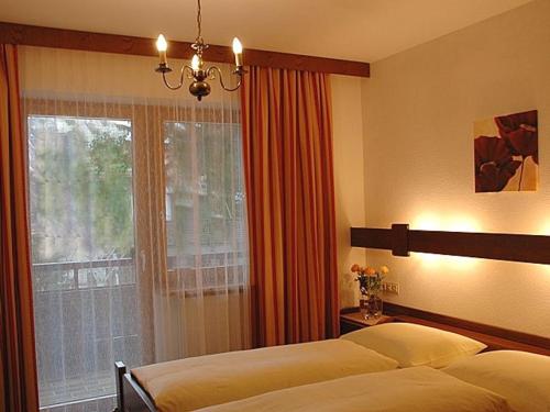 1 dormitorio con 2 camas y ventana en Appartements Vilsalp, en Tannheim