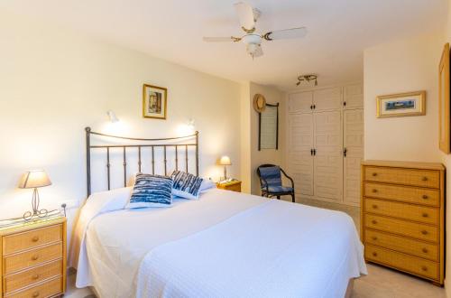 a bedroom with a large white bed with blue pillows at La Nuestra CaRo in Salobreña