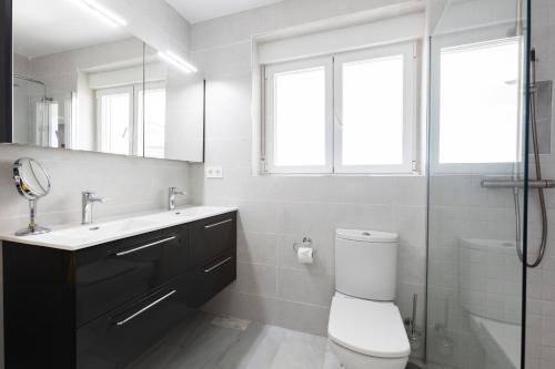 a bathroom with a toilet and a sink and a mirror at La Nuestra CaRo in Salobreña