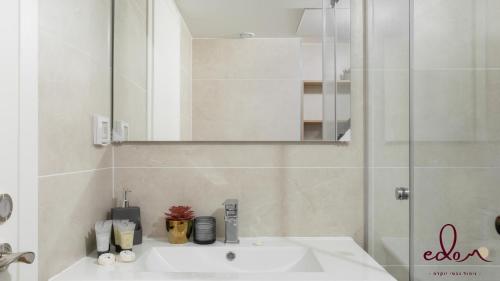 a bathroom with a sink and a mirror and a shower at Luxury living 100 meter from the beach - by Edom in Eilat